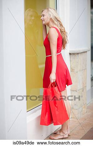 Stock Image - Woman window shopping on street. Fotosearch