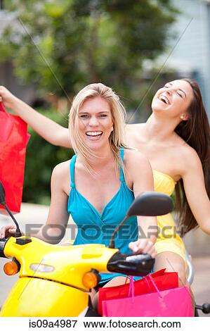 Women carrying shopping bags on scooter View Large Photo Image Stock Photo - Women carrying shopping bags on scooter. Fotosearch