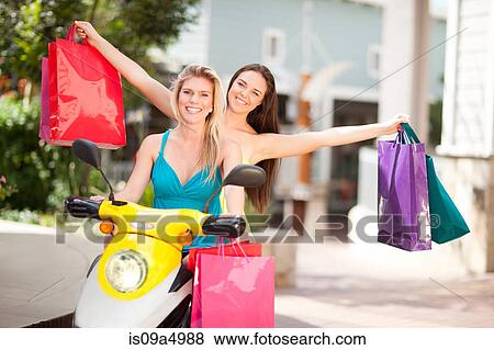 Women carrying shopping bags on scooter View Large Photo Image Stock Photo - Women carrying shopping bags on scooter. Fotosearch