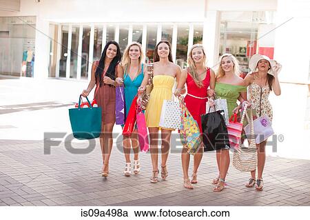Stock Image - Women carrying shopping bags outdoors. Fotosearch