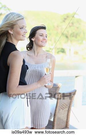 Stock Photo - Women drinking wine together outdoors. Fotosearch