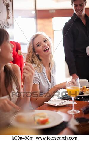 Picture - Women having breakfast together in cafe. Fotosearch