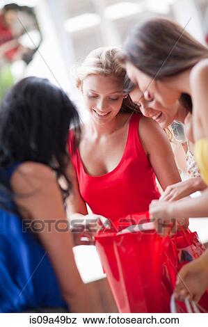 Women looking in shopping bag View Large Photo Image Stock Photo - Women looking in shopping bag. Fotosearch