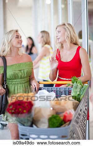 Picture - Women pushing shopping cart. Fotosearch