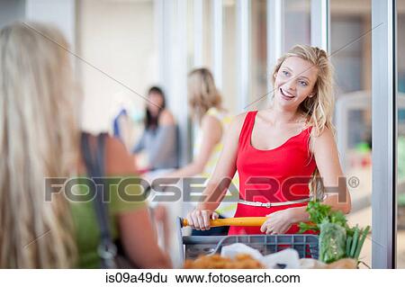 Stock Photograph - Women pushing shopping cart. Fotosearch