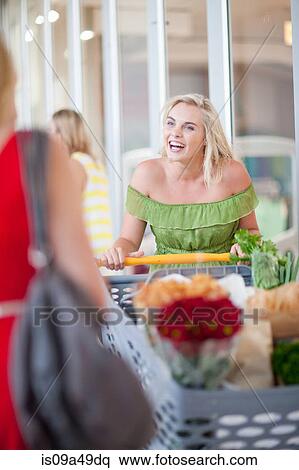Stock Photography - Women pushing shopping cart. Fotosearch
