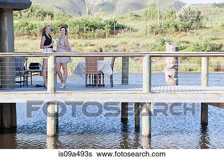 Women standing on wooden deck outdoors View Large Photo Image Stock Photograph - Women standing on wooden deck outdoors. Fotosearch