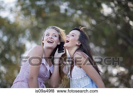 Stock Photo - Women talking on cell phone outdoors. Fotosearch