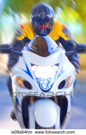 Picture - Blurred view of man riding motorcycle. Fotosearch
