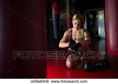 Stock Photograph - Boxer wrapping her hands in gym. Fotosearch