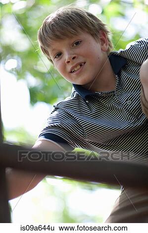 Stock Photograph - Boy climbing jungle gym outdoors. Fotosearch