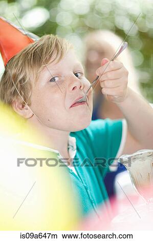Picture - Boy having ice cream sundae at party. Fotosearch