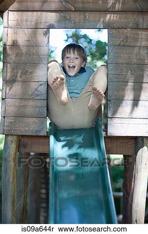 Stock Photography - Boy playing on slide outdoors. Fotosearch