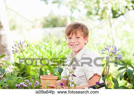 Boy potting plants outdoors View Large Photo Image Stock Photography - Boy potting plants outdoors. Fotosearch