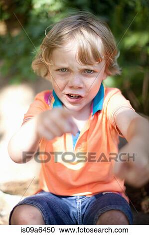 Stock Image - Boy punching the air outdoors. Fotosearch