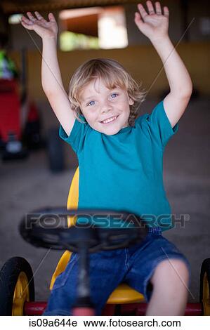 Stock Image - Boy riding go-kart in garage. Fotosearch
