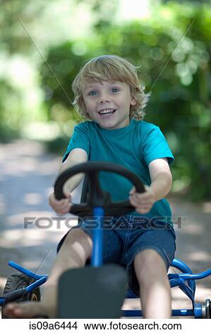 Boy riding go-kart on path View Large Photo Image Picture - Boy riding go-kart on path. Fotosearch