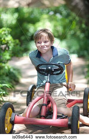 Boy riding go-kart on path View Large Photo Image Stock Image - Boy riding go-kart on path. Fotosearch