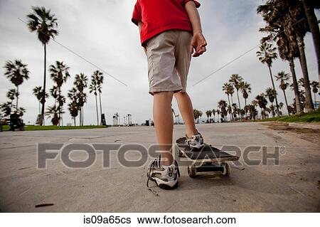 Boy riding on skateboard in park View Large Photo Image Stock Photograph - Boy riding on skateboard in park. Fotosearch