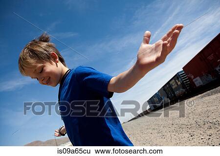 Boy shrugging by train tracks View Large Photo Image Stock Photograph - Boy shrugging by train tracks. Fotosearch
