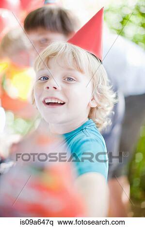 Stock Photography - Boy wearing party hat outdoors. Fotosearch