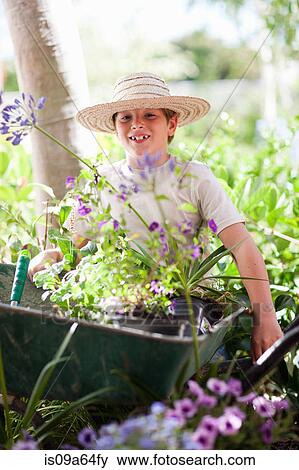 Stock Photo - Boy wearing straw hat in garden. Fotosearch