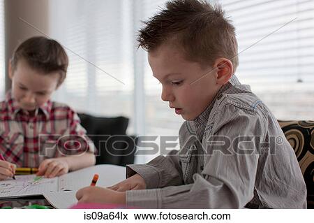 Stock Photo - Boys coloring together at table. Fotosearch
