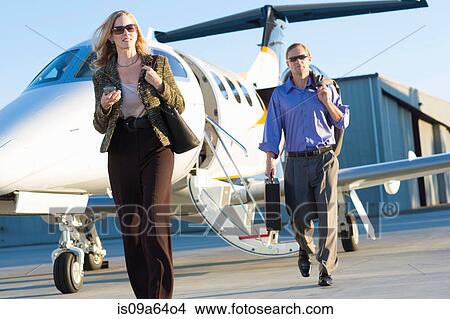 Picture - Business people on airplane runway. Fotosearch