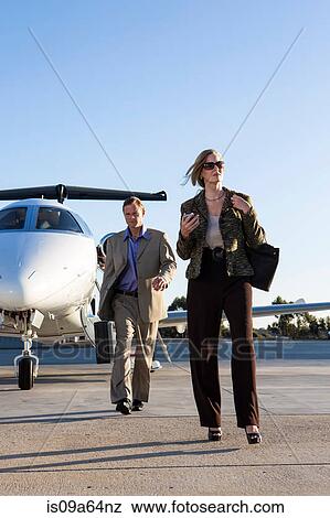 Stock Photo - Business people on airplane runway. Fotosearch
