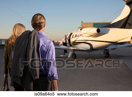 Stock Photography - Business people on airplane runway. Fotosearch