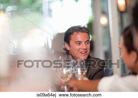 Stock Image - Business people toasting in restaurant. Fotosearch