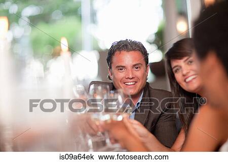 Stock Image - Business people toasting in restaurant. Fotosearch
