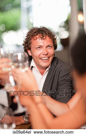 Stock Image - Business people toasting in restaurant. Fotosearch