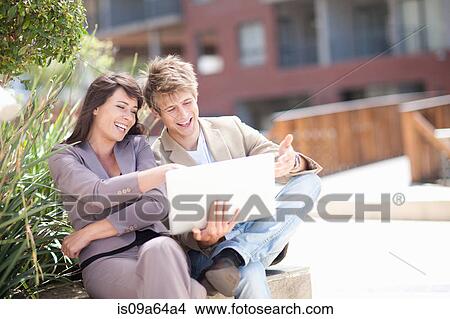 Picture - Business people using laptop outdoors. Fotosearch