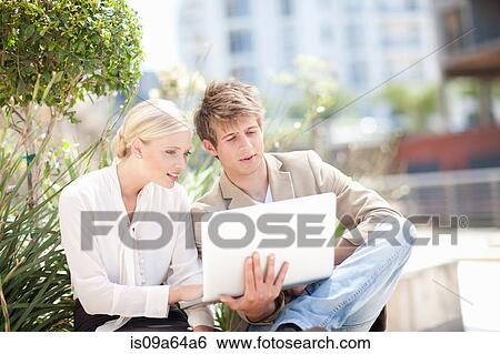 Stock Photograph - Business people using laptop outdoors. Fotosearch