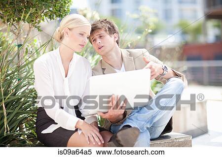 Stock Photography - Business people using laptop outdoors. Fotosearch