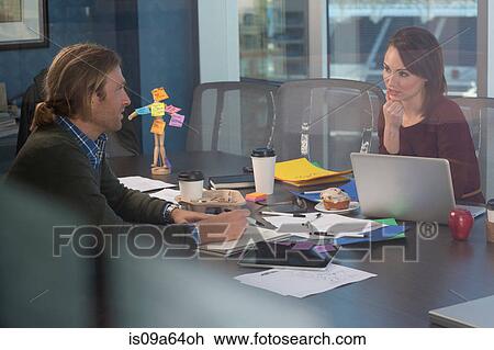 Stock Image - Business people working at desk. Fotosearch