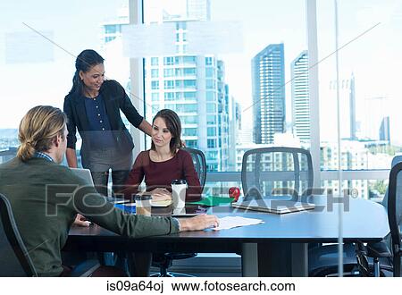 Stock Image - Business people working at desk. Fotosearch