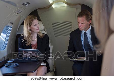 Stock Image - Business people working on airplane. Fotosearch