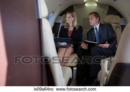 Stock Image - Business people working on airplane. Fotosearch