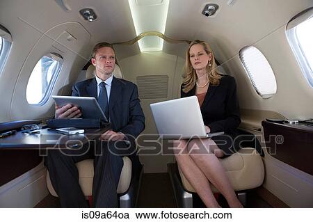 Stock Image - Business people working on airplane. Fotosearch