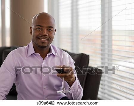 Stock Image - Businessman having glass of wine. Fotosearch