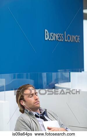 Stock Photograph - Businessman listening to earphones. Fotosearch