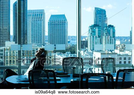 Businessman relaxing at desk in office View Large Photo Image Stock Photo - Businessman relaxing at desk in office. Fotosearch