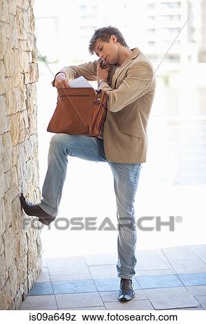 Businessman rooting through briefcase View Large Photo Image Stock Photo - Businessman rooting through briefcase. Fotosearch