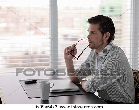 Stock Photo - Businessman sitting at desk. Fotosearch