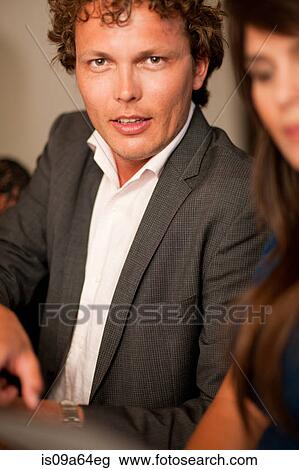 Stock Image - Businessman sitting at table. Fotosearch