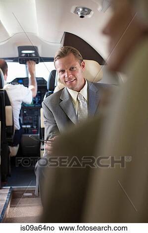Businessman sitting in airplane View Large Photo Image Picture - Businessman sitting in airplane. Fotosearch