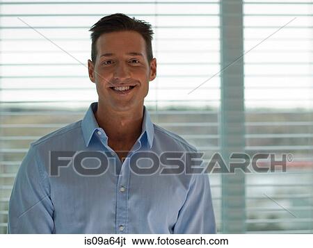Stock Photograph - Businessman smiling by window. Fotosearch