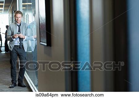 Businessman using cell phone in office View Large Photo Image Picture - Businessman using cell phone in office. Fotosearch